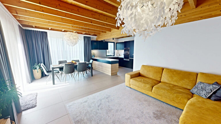 Otvorená obývacia časť s kuchyňou a žltou sedačkou — ukážka home stagingu